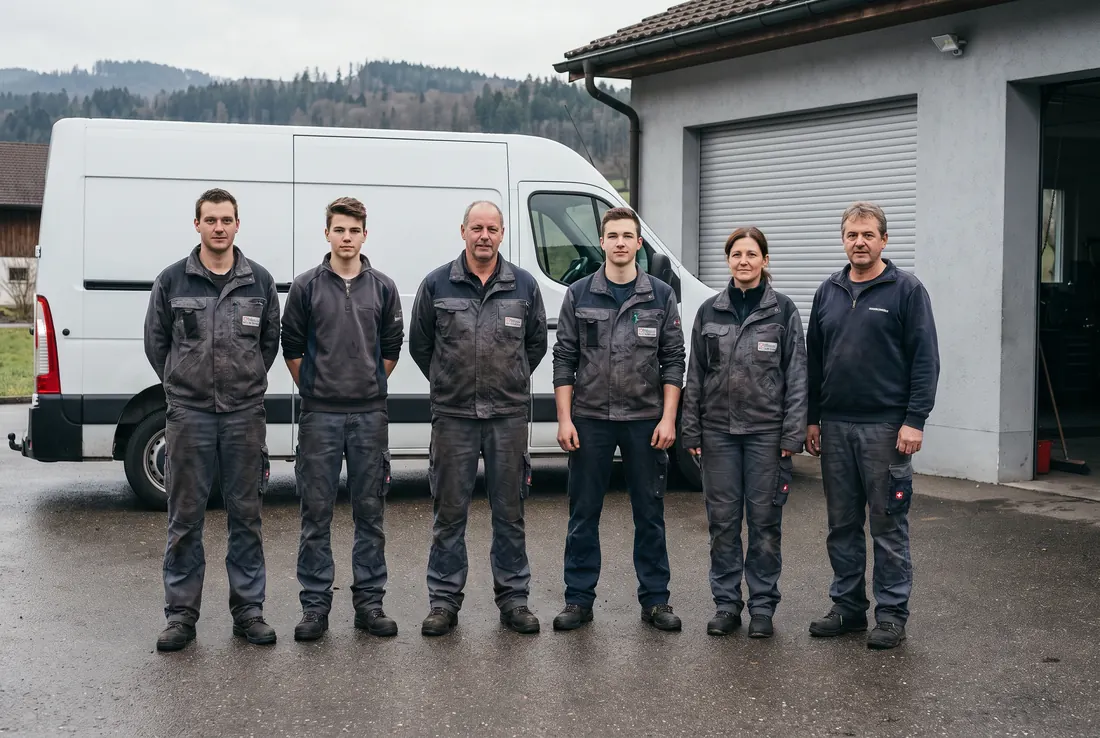 Sechs Mitarbeitende der Roth Haustechnik AG vor dem Firmenwagen und der Werkstatt in Uster